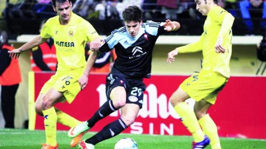 Santi Mina avanza con la pelota entre los jugadores del Villarreal Dorado y Trigueros durante el encuentro de Liga disputado anoche en el estadio de El Madrigal. // LOF