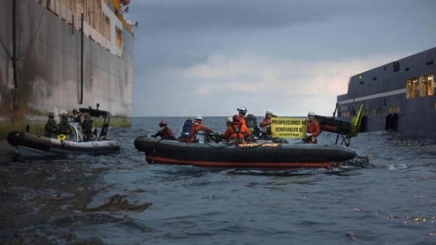 Un momento de la protesta de los miembros de Greenpeace junto al barco de Repsol, junto a ellos la lancha de la Armada.