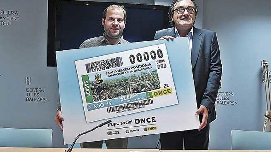 Miquel Mir y José Vilaseca muestran el cupón dedicado a la posidonia, ayer.