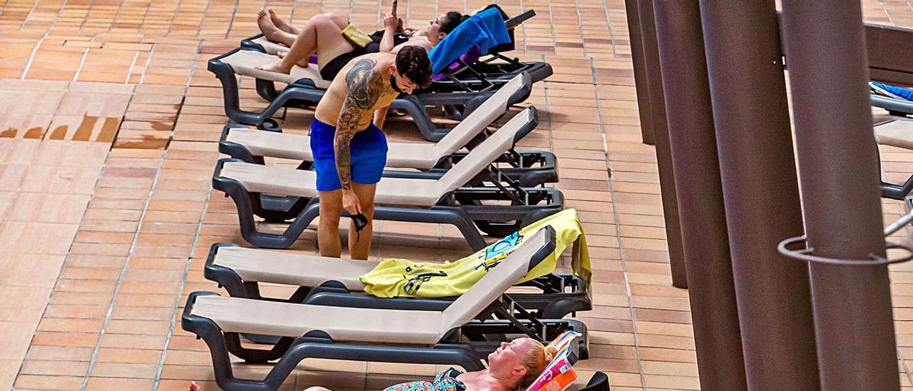 Turistas tomando el sol en la terraza de un hotel de Benidorm. | DAVID REVENGA