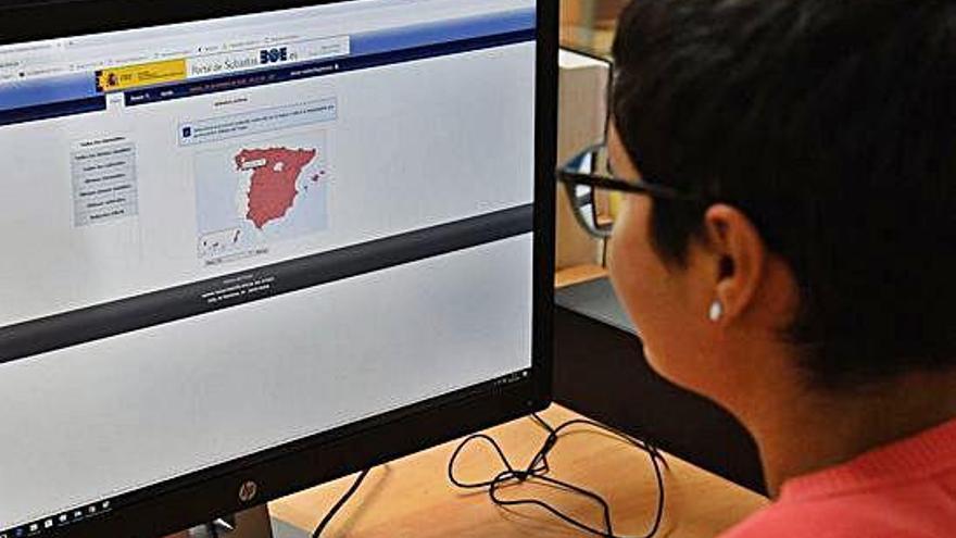 Una joven consulta el mapa de subastas judiciales en el portal del &#039;Boletín Oficial del Estado&#039;.