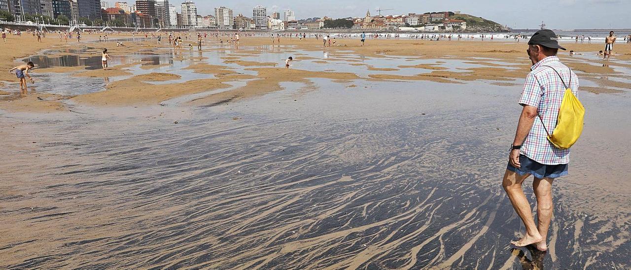 Mancha de carbón a la altura de la escalera 12 de la playa de San Lorenzo, en el verano de 2019.