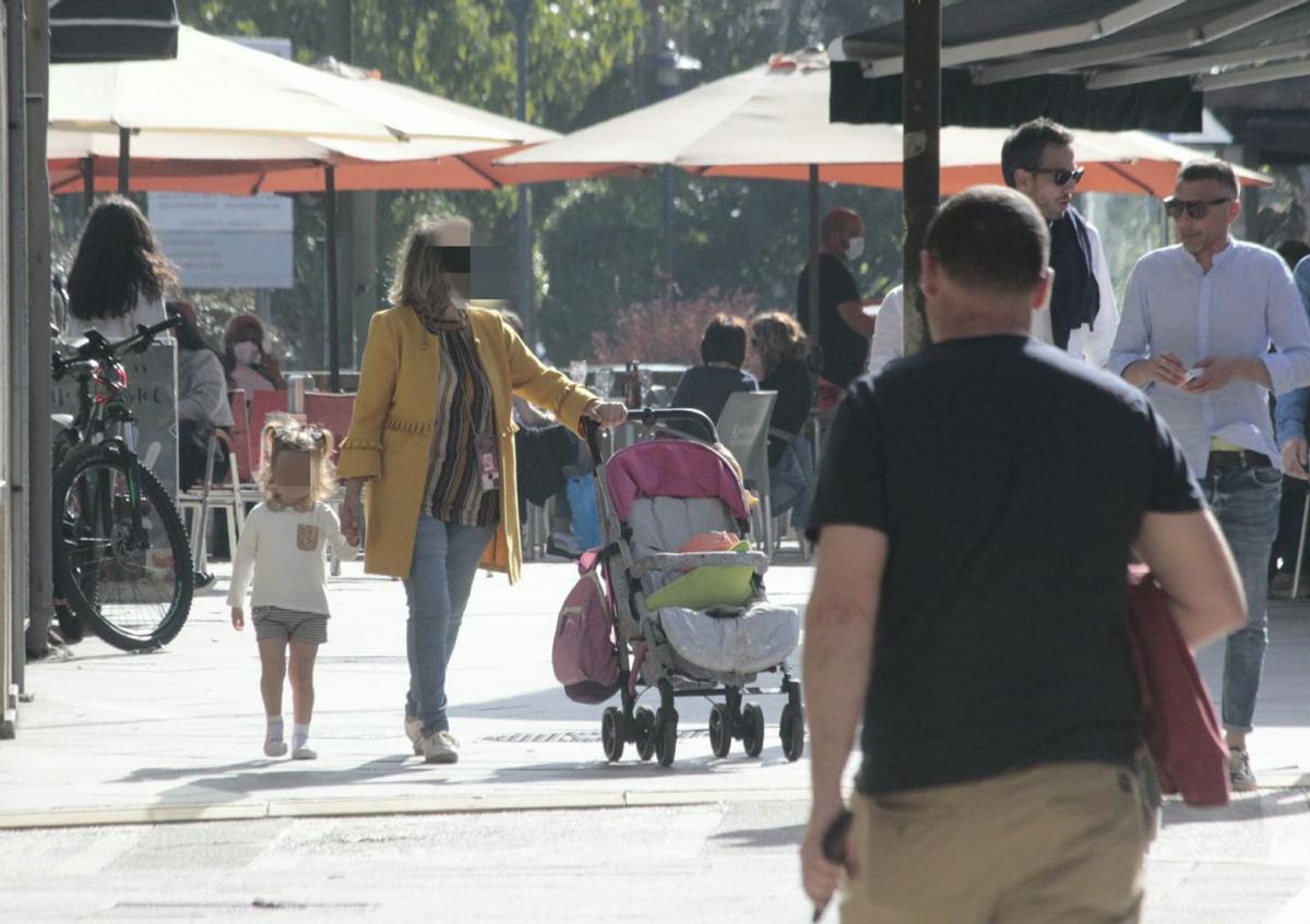 Una mujer con el carrito y una niña pequeña de la mano, ayer en Cangas.
