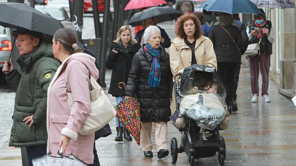 Dos mujeres pasean a un bebé por el centro de Ourense.