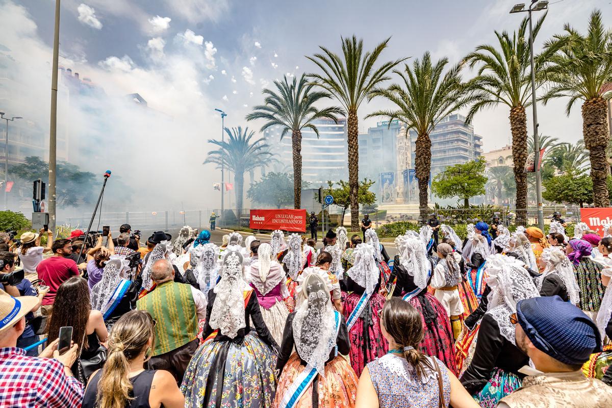 La comitiva festera atiende una de las mascletás en Luceros, en 2022.