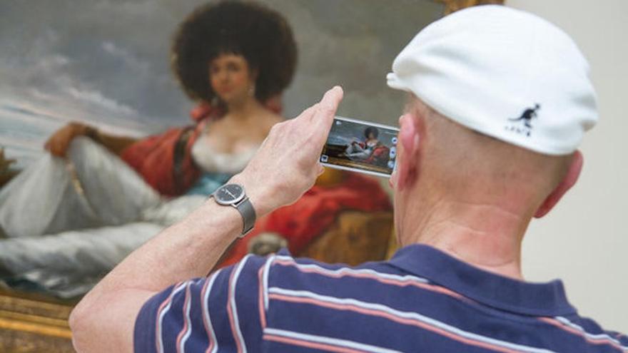 Un visitante del Thyssen fotografía un cuadro con su teléfono móvil.