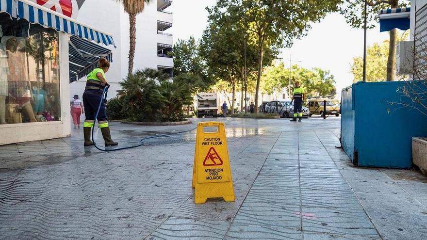 Operarios de Limpieza baldean la acera en una calle de Las Albarizas.