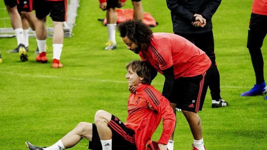 Marcelo bromea con Modric en el escenario del partido en el entrenamiento de ayer.