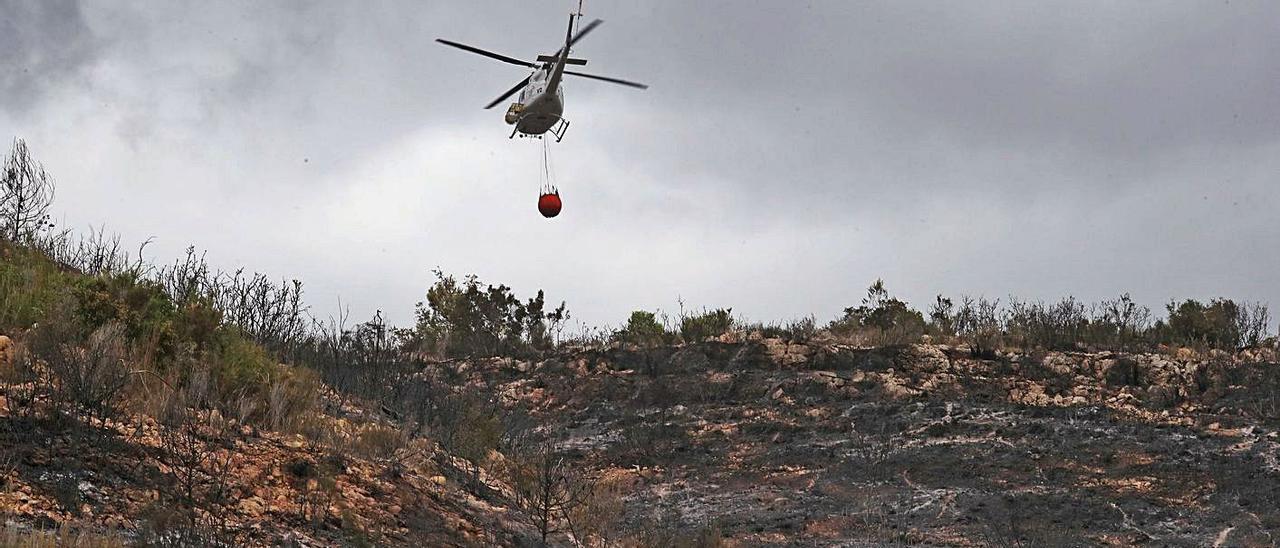 Un helicóptero trabaja en las labores de extinción del último incendio de  Rafelguaraf. | J. M. LÓPEZ