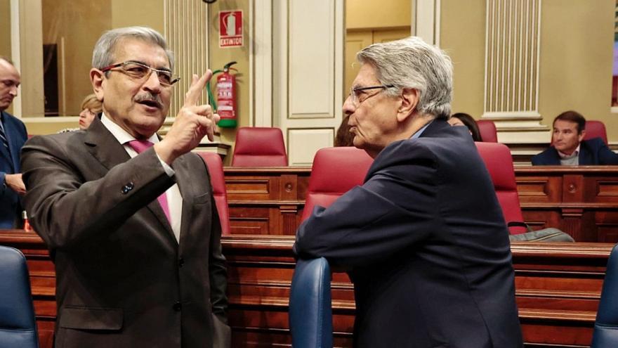 Román Rodríguez gesticula con la mano durante una conversación, ayer, con el también consejero Julio Pérez.