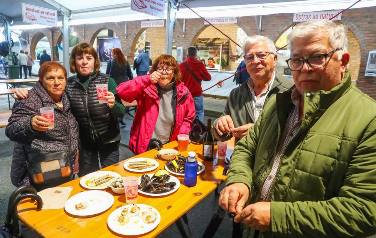 Un grupo toma mejillones, zamburiñas y navajas. | // IÑAKI ABELLA
