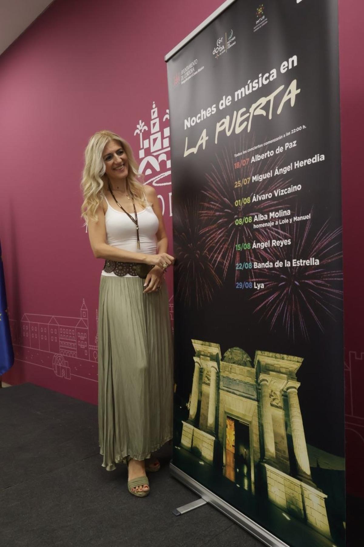 Lourdes Morales, con el cartel del ciclo 'Noches de música en la puerta'.