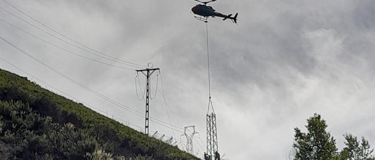 El helicóptero coloca una de las nuevas torres.