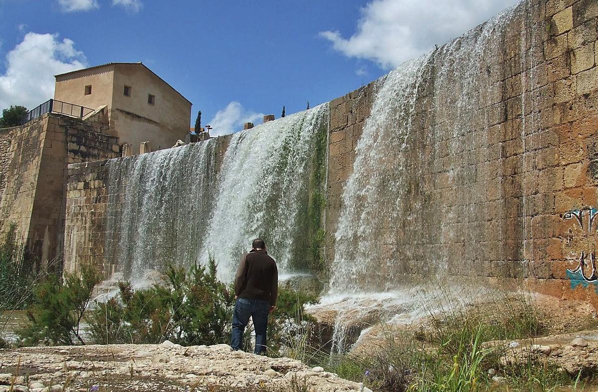 El Assut de Sant Joan, también conocido como Assut Nou, y dos de las cartas con profesiones relacionadas con el patrimonio hidráulico. | J.A.RICO / INFORMACIÓN