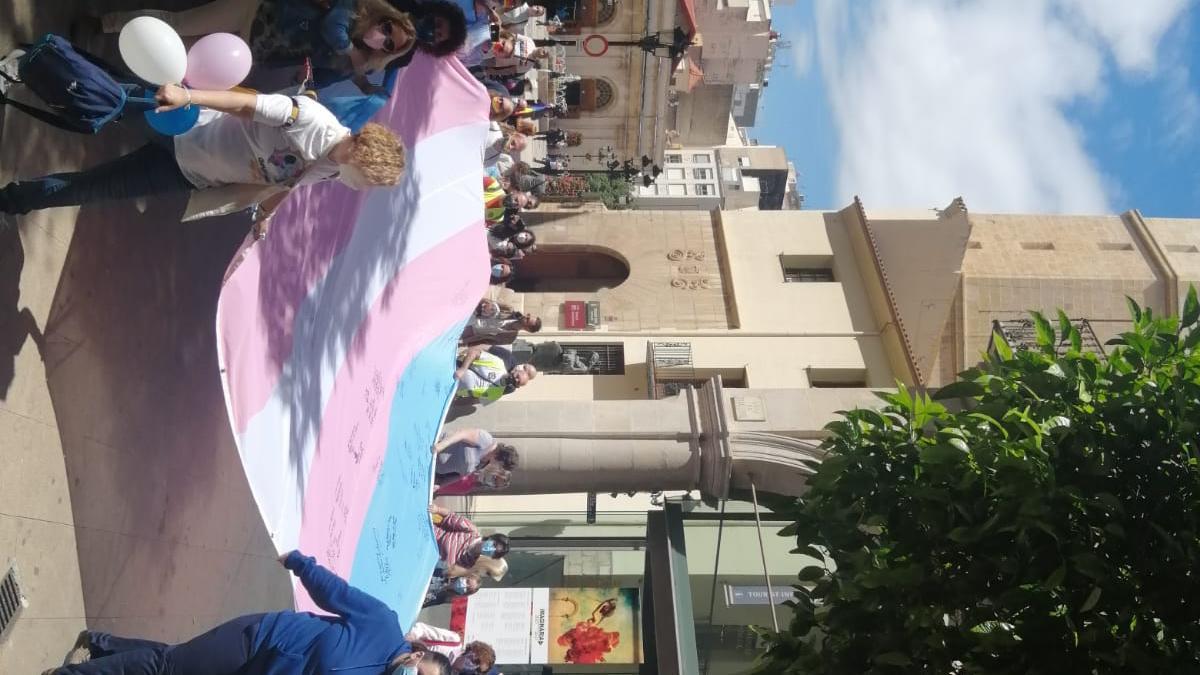 Parte de los asistentes a la concentración con la bandera trans firmada