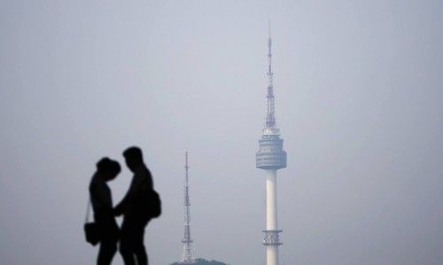 A couple is silhouetted against the backdrop of N Seoul Tower, commonly known as Namsan Tower, in Seoul