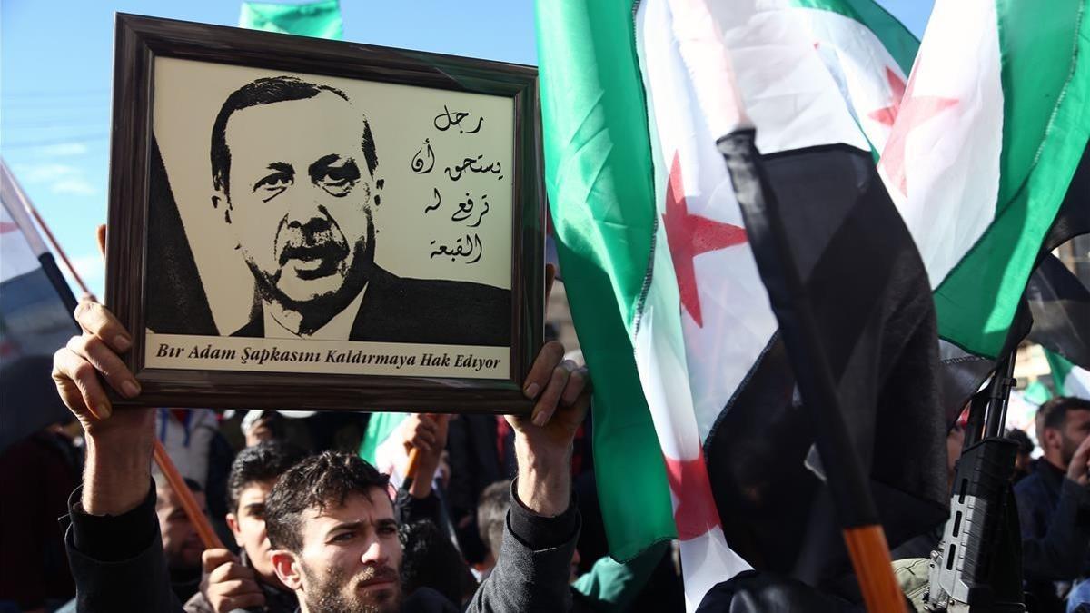 Simpatizantes de los rebeldes sirios levantan un retrato de Erdogan en apoyo de la operación turca contra las milicias kurdas, este viernes en Azaz (Siria).