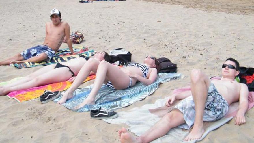 Dos menores juegan en la arena de la playa carreñense.