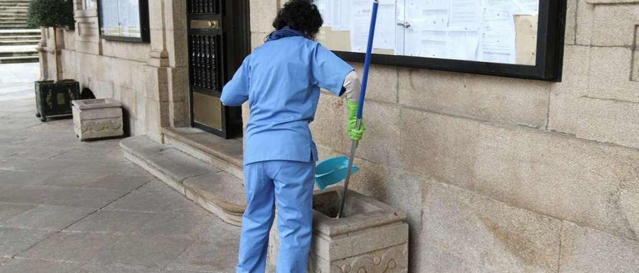 Una de las trabajadoras del servicio de limpieza en la entrada del Concello. // Iñaki Osorio