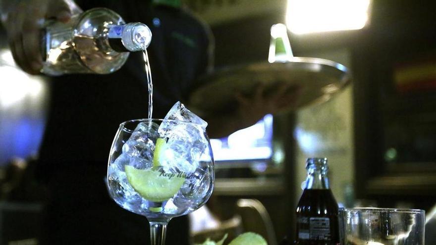 Un camarero sirve una copa en un bar.