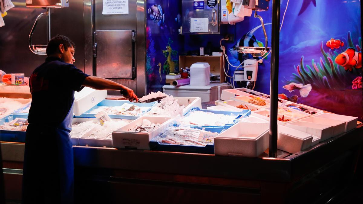 Un trabajador echa hielo a los productos de una pescadería en Madrid.