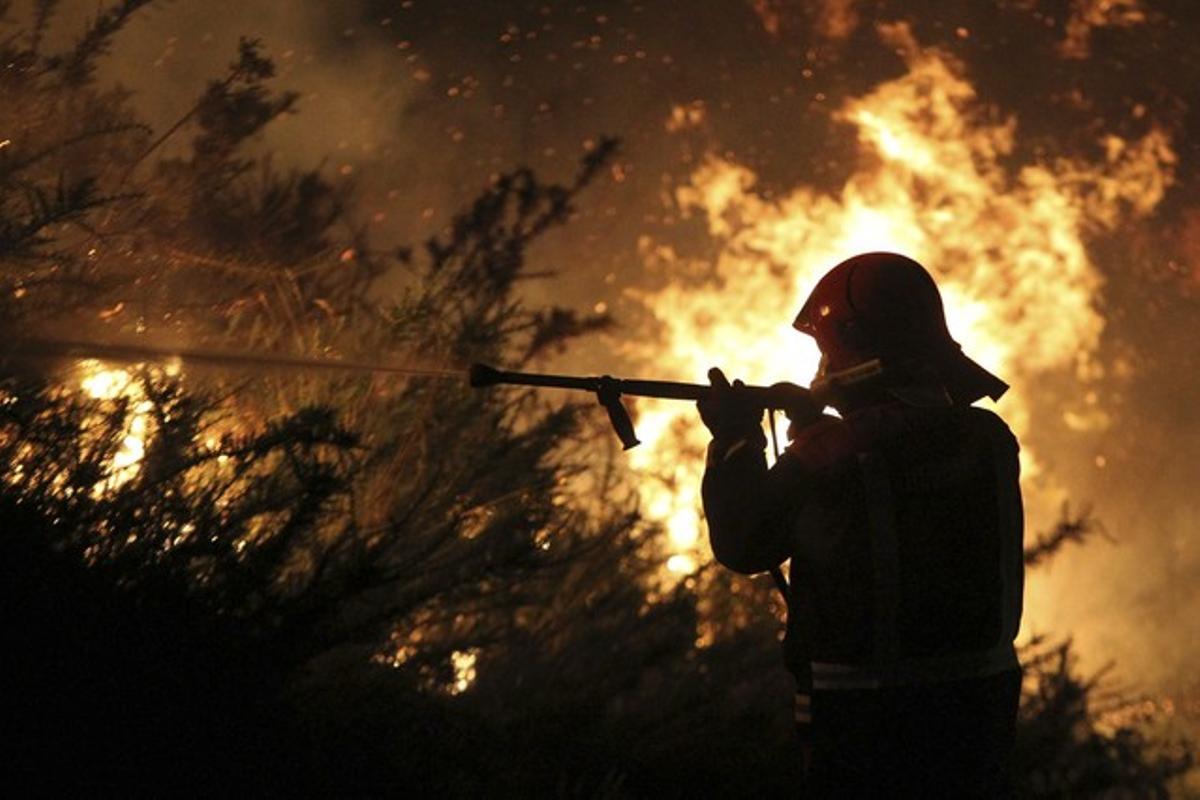 Un bomber treballa en l’extinció de l’incendi de Fornelos de Montes a Pontevedra. Un bomber treballa en l’extinció de l’incendi de Fornelos de Montes a Pontevedra.