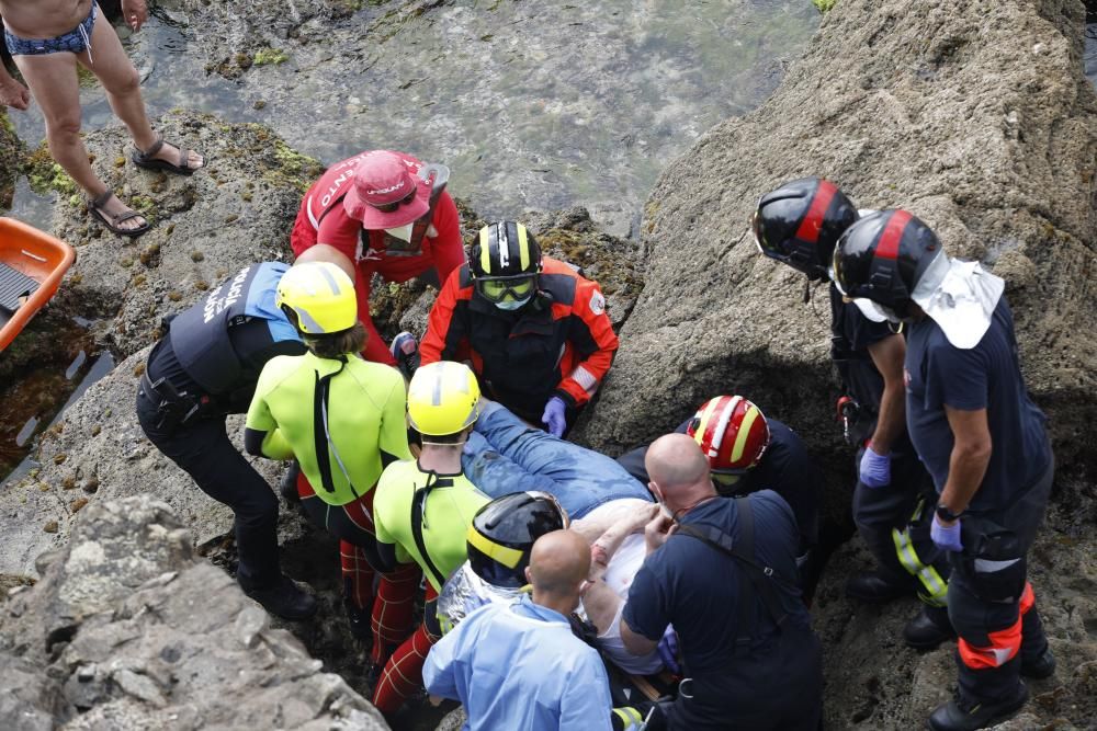Rescatan a una mujer que se precipitó a las rocas de la playa de San Lorenzo en Gijón.
