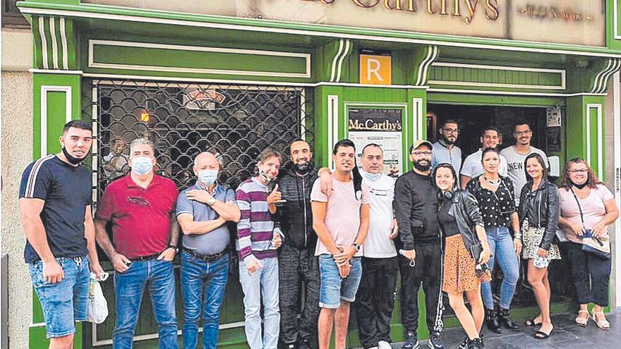 Trabajadores apostados en la fachada del pub tras la despedida.