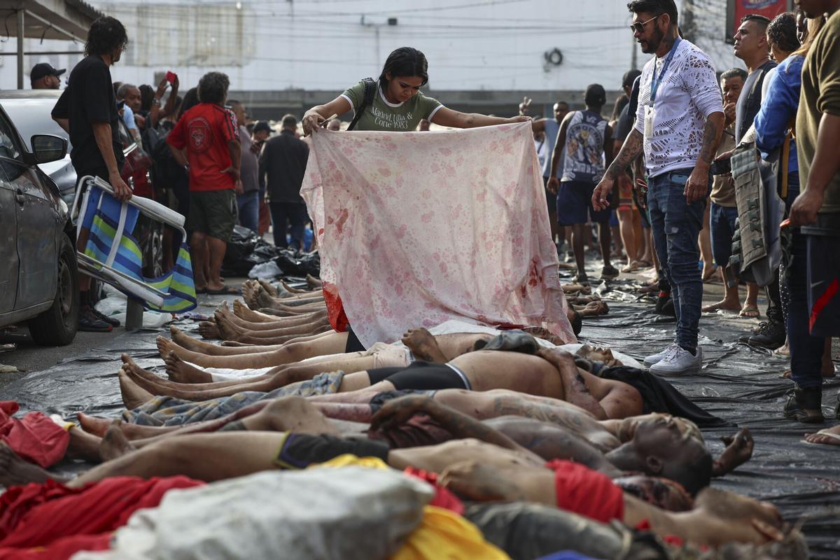 ATENCIÓN EDITORES: CONTENIDO GRÁFICO EXPLICITO ACOMPAÑA CRÓNICA: BRASIL DROGAS AME3085. RÍO DE JANEIRO (BRASIL), 29/10/2025.- Personas observan cuerpos sin vida en una calle este miércoles, en Río de Janeiro (Brasil). El megaoperativo del martes, en el que participaron 2.500 agentes, tenía como objetivo detener a cabecillas del Comando Vermelho, una de las organizaciones criminales mas antiguas y peligrosas de Rio. EFE/ André Coelho. ATENCIÓN EDITORES: CONTENIDO GÁFICO EXPLICITO ACOMPAÑA CRÓNICA: BRASIL DROGAS