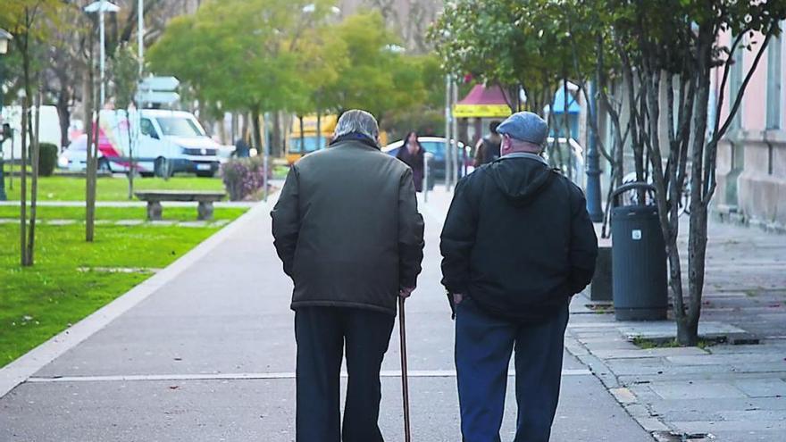 Dos ancianos, paseando por una calle. // Rafa Vázquez