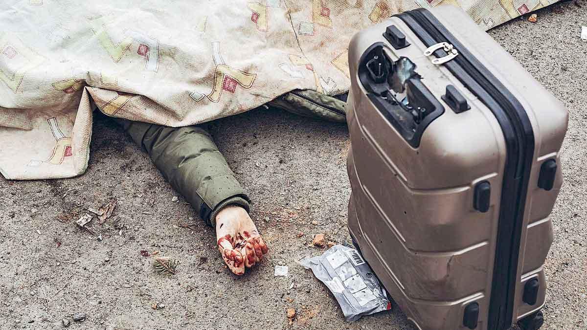 Un hombre yace muerto junto a su maleta tras un bombardeo del ejército ruso en el punto de evacuación de Irpin.