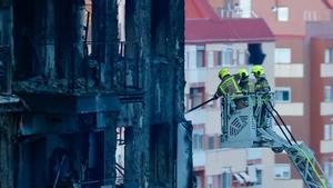 Bomberos retiran placas de uno de los edificios calcinados en Campanar.