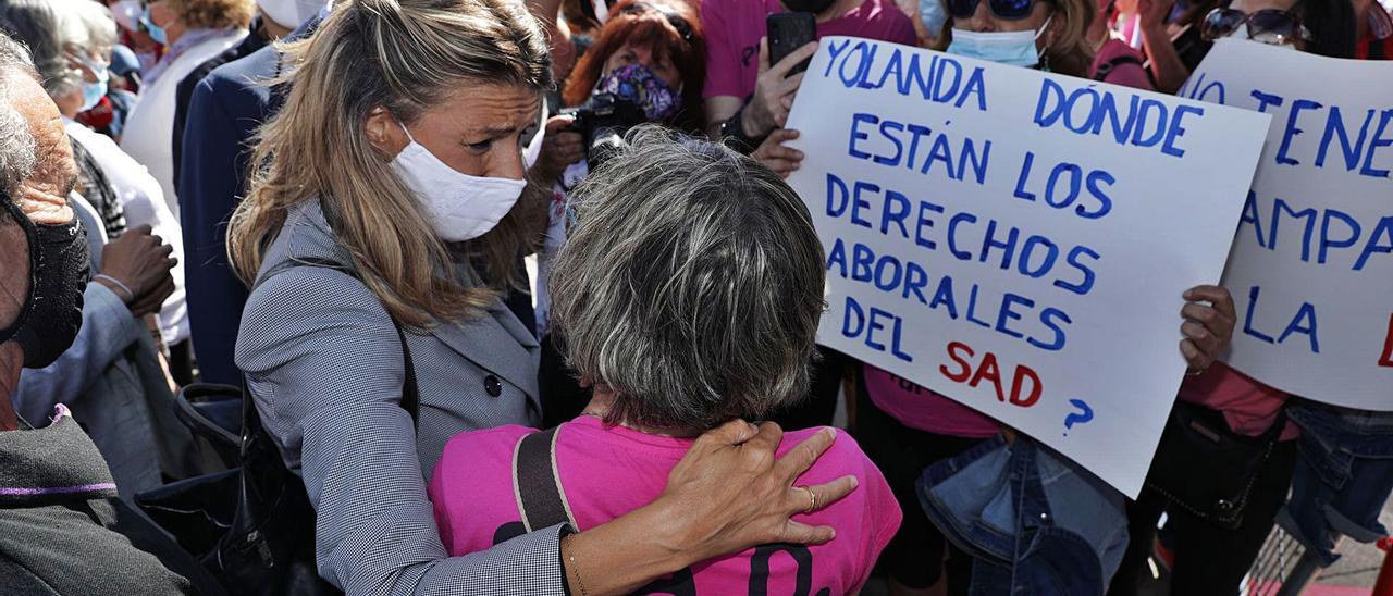 Yolanda Díaz, ministra de Trabajo, se abraza a una trabajadora del servicio de ayuda a domicilio durante su encuentro con los manifestantes. | Juan Plaza