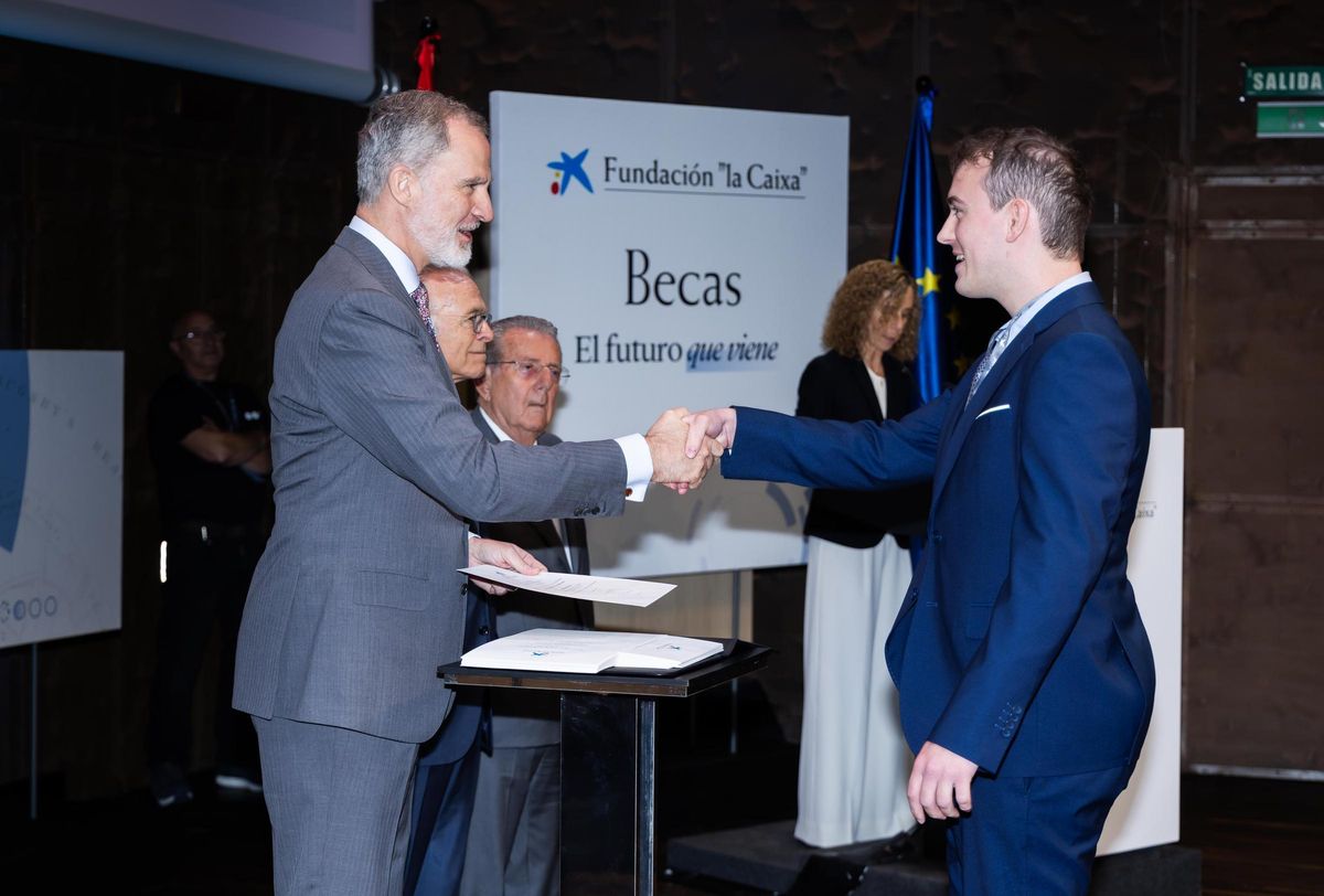 Su Majestad el Rey haciendo entrega del certificado de la beca al estudiante Javier Gómez Pérez.