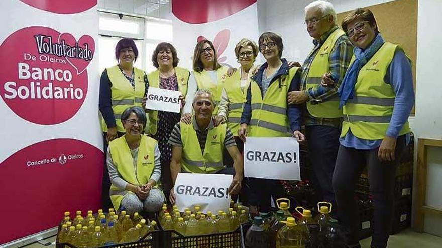 Parte del equipo del Voluntariado de Oleiros, el viernes pasado en el local, con el aceite de la última campaña.