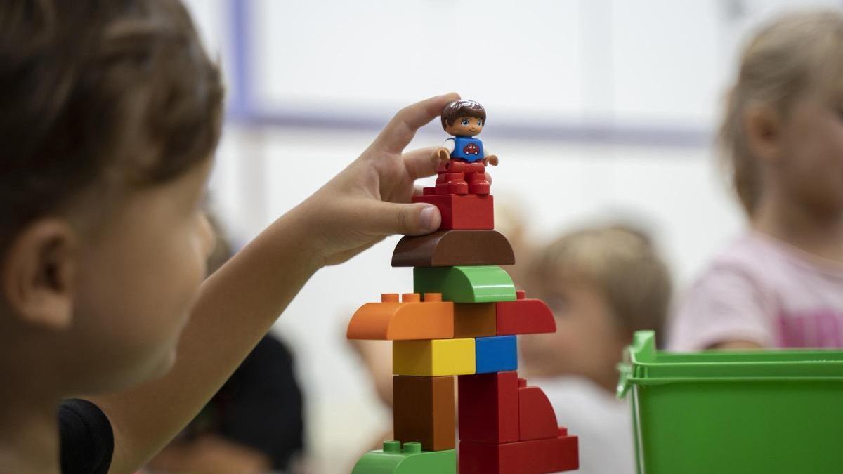 Un niño se divierte con un juego de construcción, en un aula de infantil.