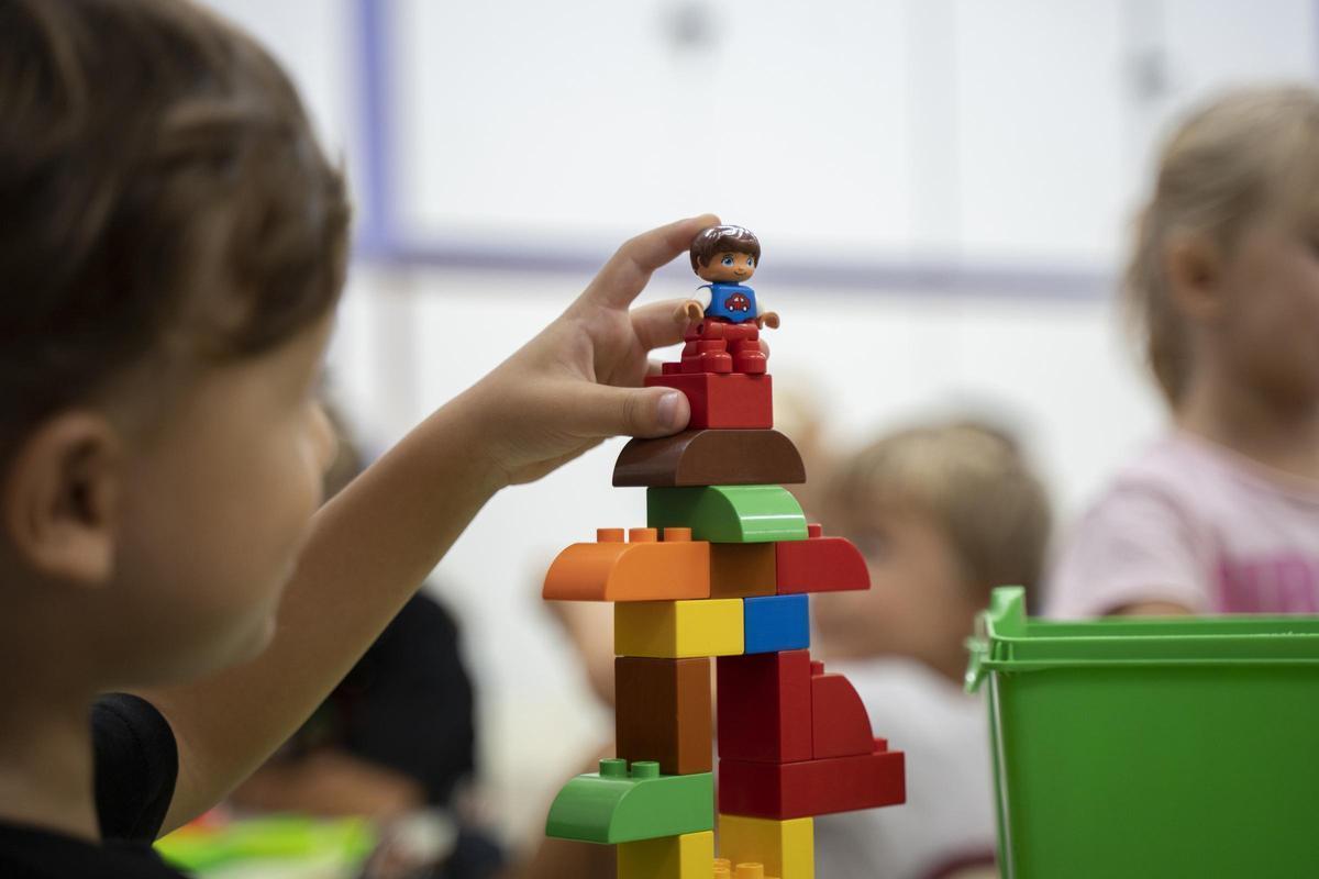 Un niño se divierte con un juego de construcción, en un aula de infantil.