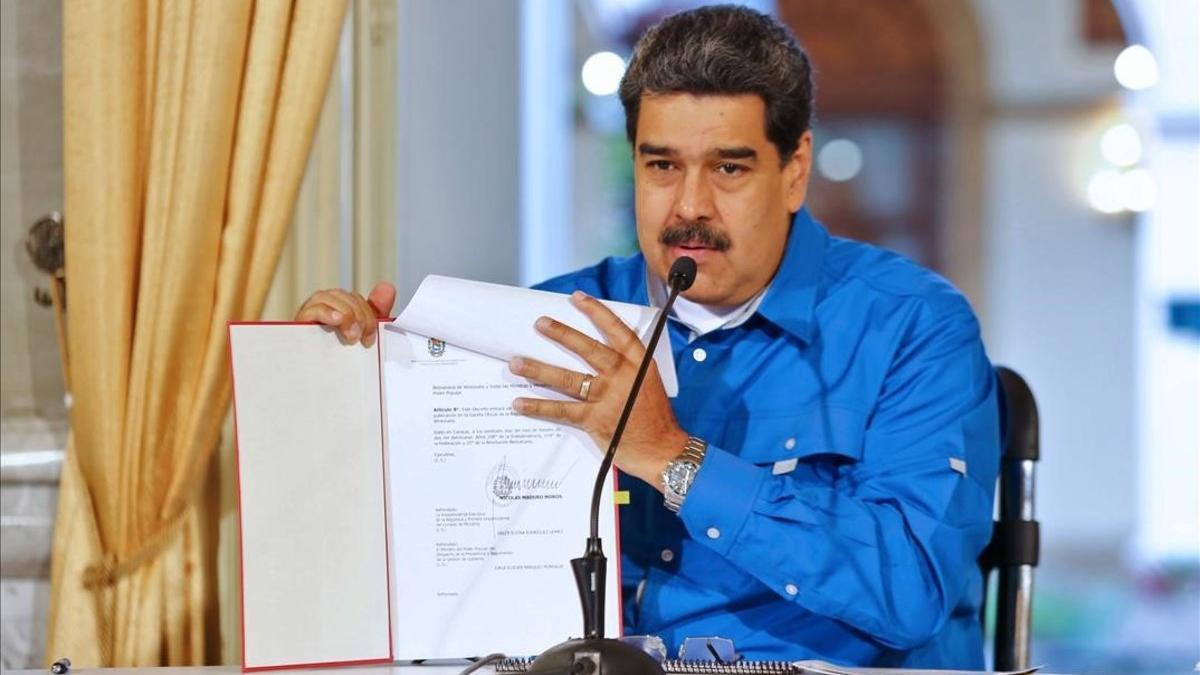 El presidente venezolano, Nicolás Maduro, muestra un documento durante un discurso ante la nación.