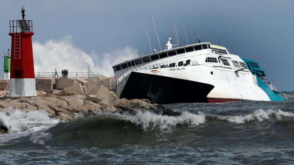 El buque "Pinar del Rio" de la naviera Balearia, que el pasado agosto encalló en la bocana del puerto, es golpeado por las olas durante la jornada de hoy, miércoles.