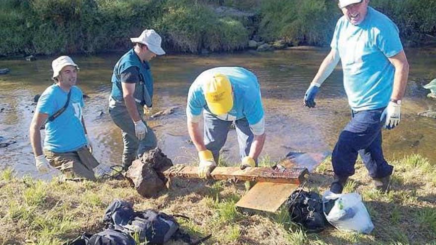 Voluntarios de Adega limpian el cauce del Lagares dentro del &quot;Proyecto Ríos&quot;.  // A. M.