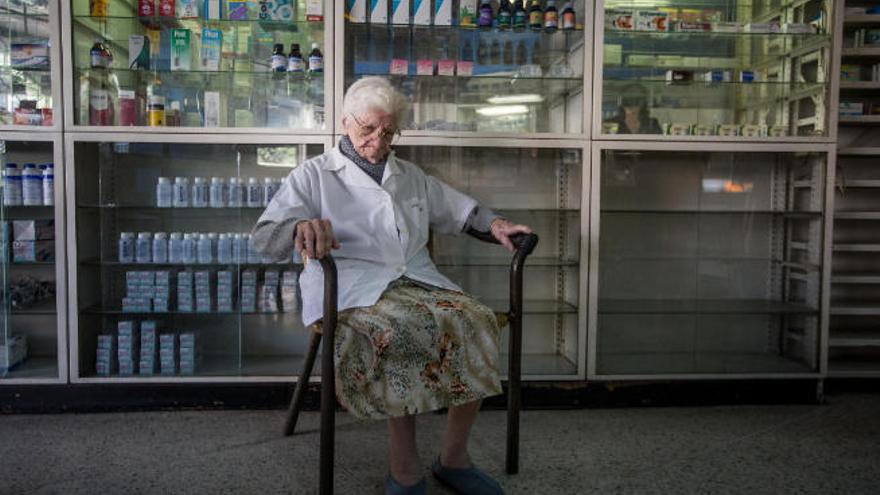 Una anciana espera por unos medicamentos en una farmacia desabastecida de Caracas.