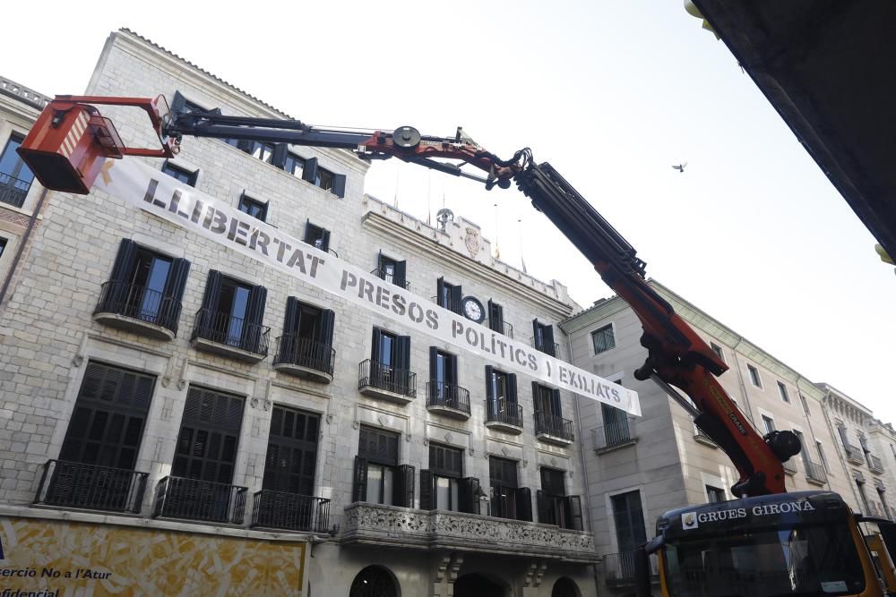 Pengen la pancarta en suport dels presos davant de l'Ajuntament de Girona