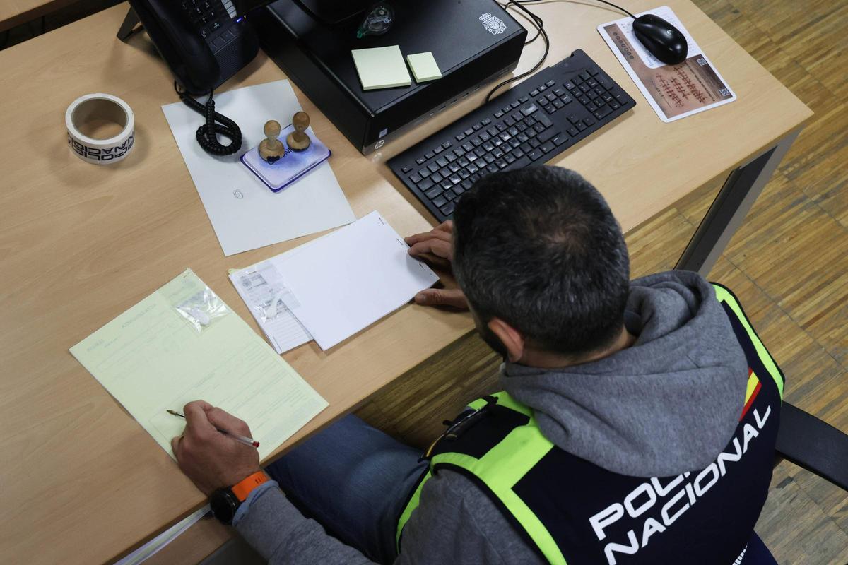 Uno de los agentes, con un acta de incautación de sustancias estupefacientes.