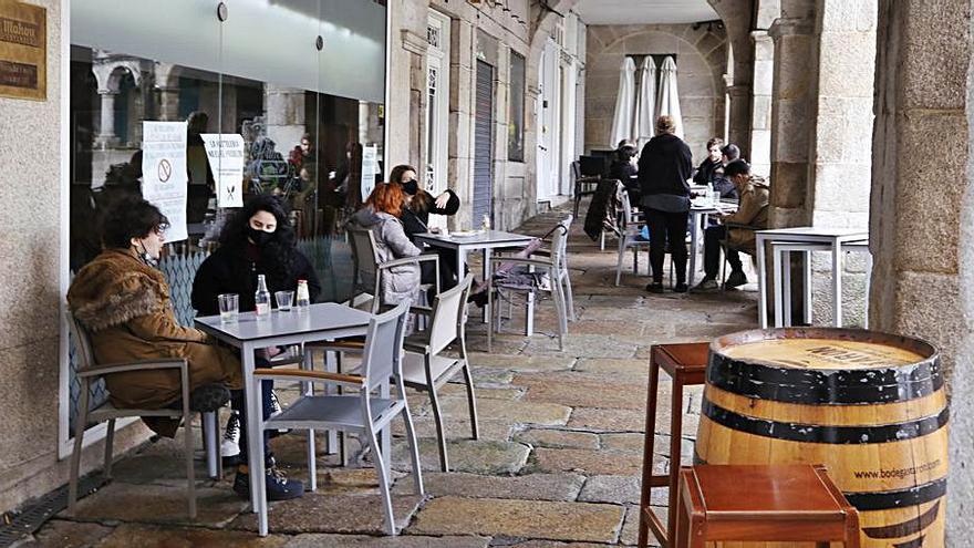 Gente en la terraza de una cafetería de la Praza da Constitución.