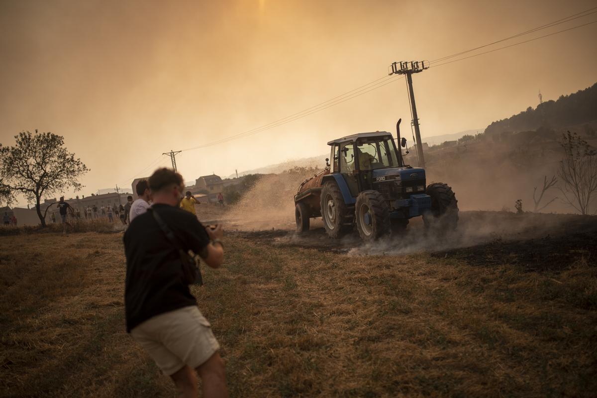  Vecinos colaboran en las labores de extinción en un incendio forestal, de Sant Fruitós del Bages, Barcelona.