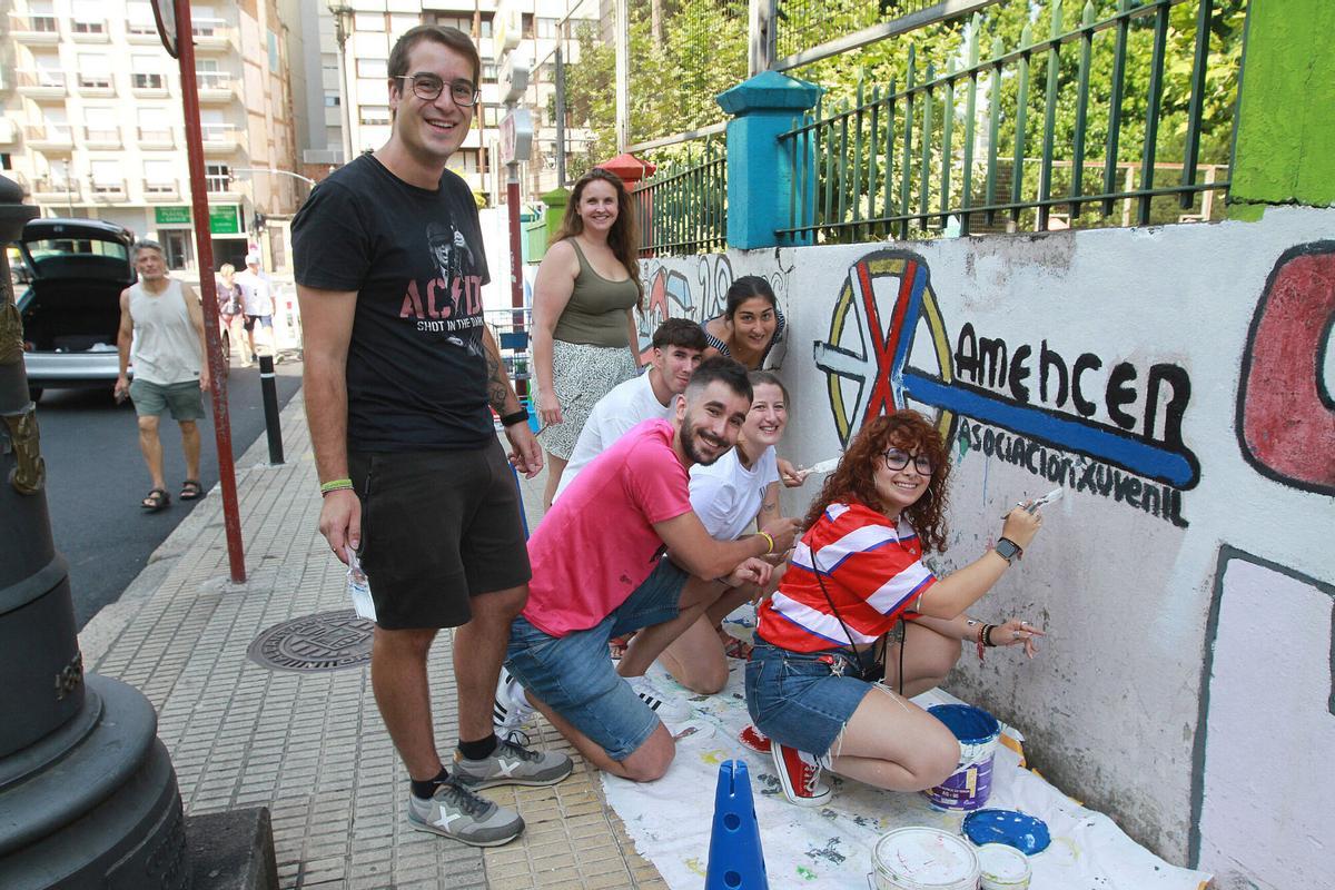 La sociacion juvenil Amencer pintando el muro de campamento urbano