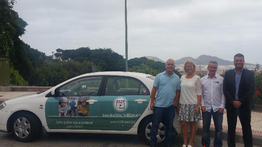 El taxi rotulado junto a los promotores de la iniciativa.