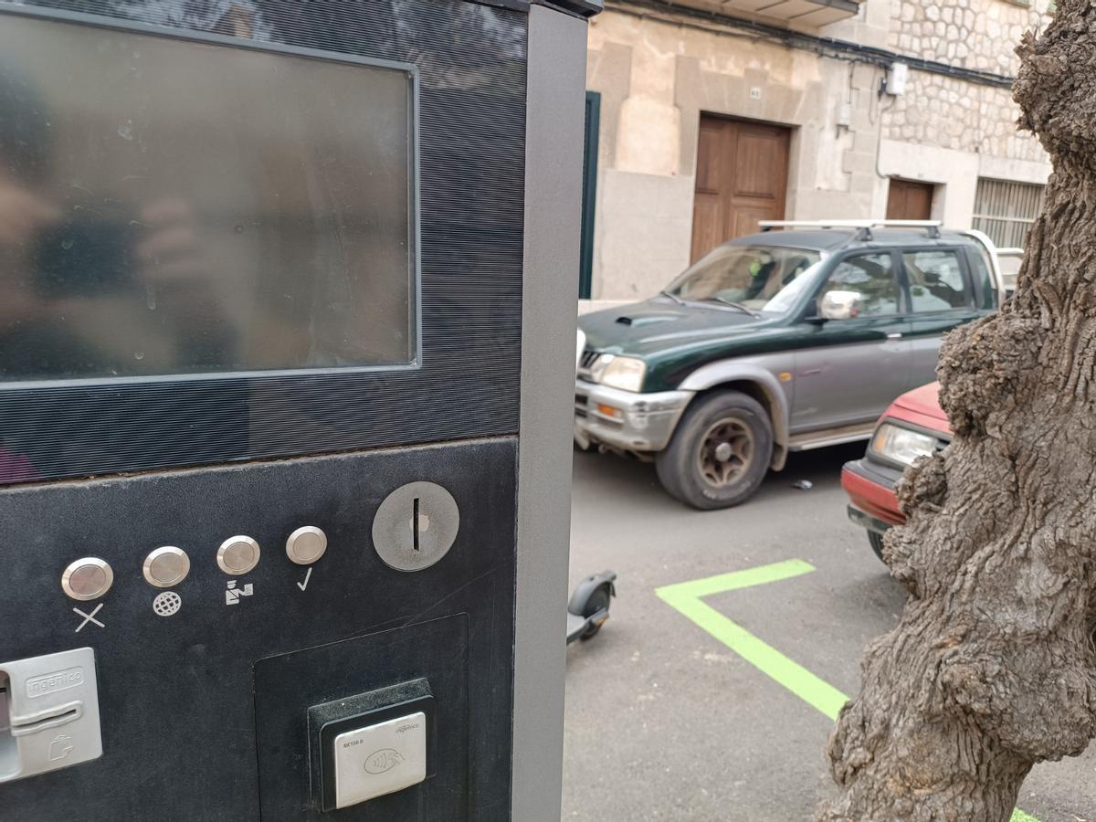 Primer plano de una máquina de ORA y una zona verde en Sóller.