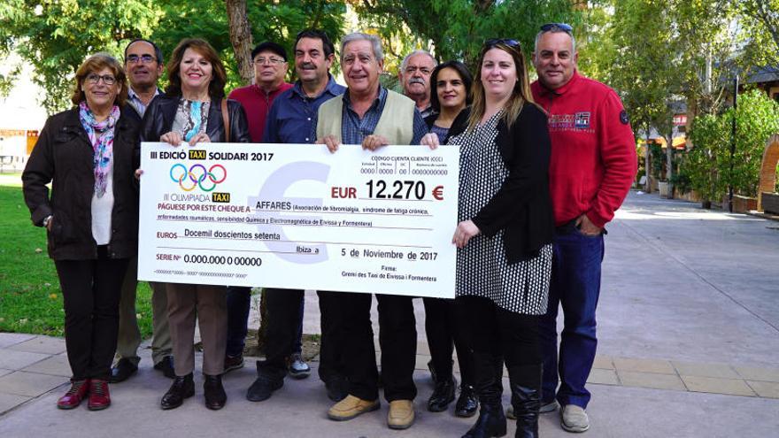 Representantes de los taxistas y de la asociación de fibromialgia, en la entrega del cheque.