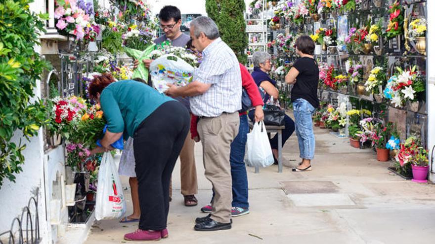 Ciudadanos enramando los nichos de sus familiares difuntos en el cementerio de San Rafael de Vecindario.